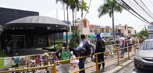Ciudadanos observan una línea de fotos de las víctimas mortales de la tragedia en la discoteca Jet Set.