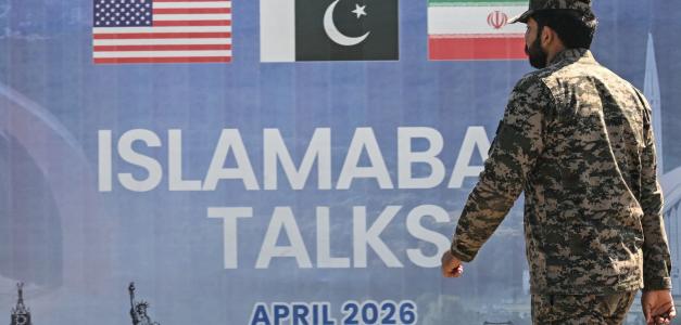 Un ranger pakistaní pasa junto a una valla publicitaria de las conversaciones de paz entre Estados Unidos e Irán en Islamabad el 12 de abril de 2026. Irán y Estados Unidos no lograron llegar a un acuerdo para poner fin a la guerra en Oriente Medio.