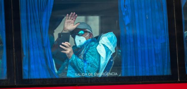 Un pasajero del crucero MV Hondius, saluda a bordo de un autobús militar tras ser trasladado en barco al puerto industrial de Granadilla de Abona, en la isla de Tenerife (Islas Canarias, España).