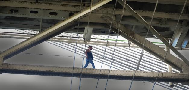 José Luis González camina sobre una barra de metal del puente Duarte, poco antes de ser capturado por la Policía.