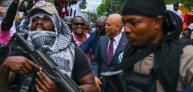 El expresidente de Haití, Michel Martelly (centro-derecha), aparece rodeado de personal de seguridad y simpatizantes a su llegada a una oficina electoral para inscribirse como candidato presidencial en Puerto Príncipe, Haití, el 23 de octubre de 2026.