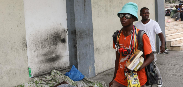 Peatones pasan ayer cerca de un hombre que duerme en una calle de Puerto Príncipe.