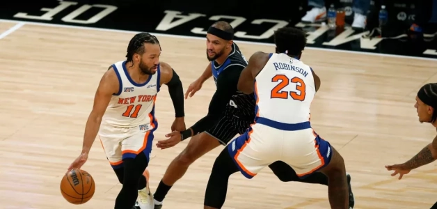El base de los Knicks Jalen Brunson avanza con el balón frente a Jalen Suggs del Magic y su compañero Mitchell Robinson en el encuentro del 7 de diciembre del 2025.