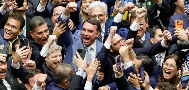 El senador Flavio Bolsonaro (C) celebra durante una sesión del Congreso Nacional que anuló el veto del presidente Lula a un proyecto de ley que reducía las penas para los condenados por el intento de golpe de Estado.