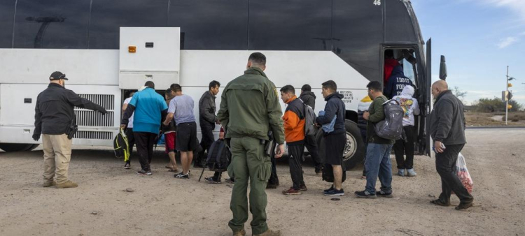 Inmigrantes suben a un autobús del Servicio de Aduanas y Protección de Fronteras de Estados Unidos tras cruzar la frontera entre México y Estados Unidos el 7 de enero de 2024 en Eagle Pass, Texas