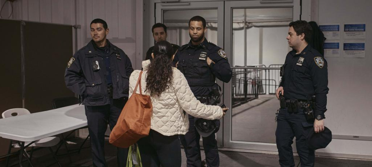 Una migrante habla con la policía en un albergue para migrantes en Randall's Island, el martes 9 de abril de 2024, en Nueva York