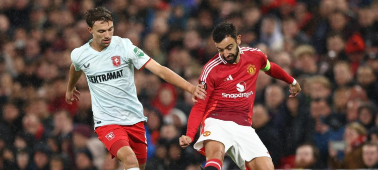 El centrocampista del FC Twente, Youri Regeer (I), corre a por el balón contra Bruno Fernandes, del Manchester United