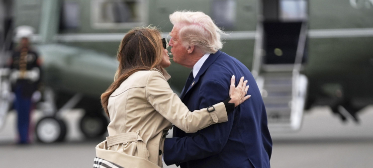 El presidente Donald Trump (derecha) besa a la primera dama Melania Trump