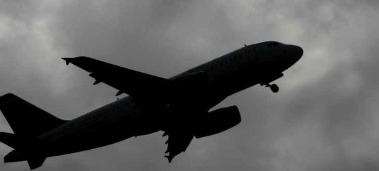 Imagen ilustra un avión en medio del cielo nublado.