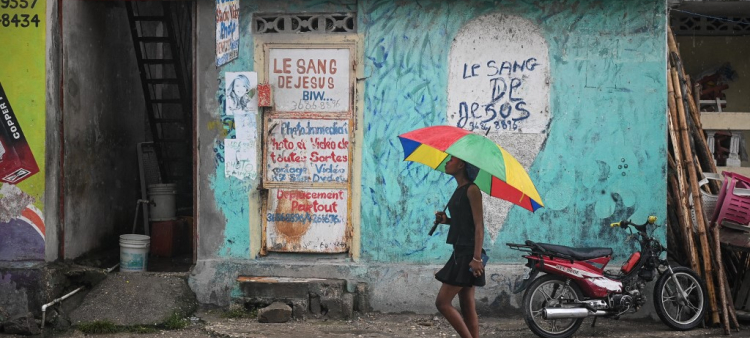 Una chica camina bajo la lluvia en Haití.
