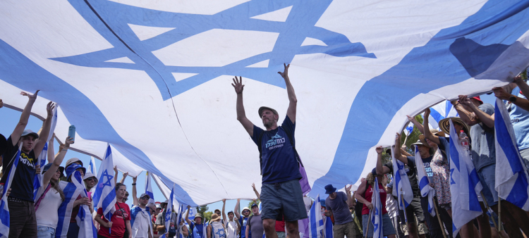 Los manifestantes ondean una gran bandera israelí