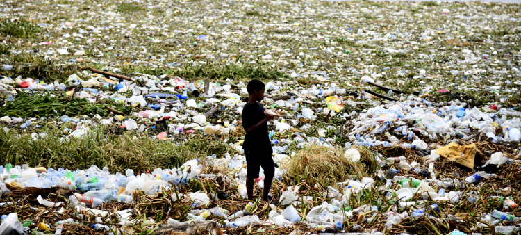 Un niño camina sobre un montón de basura y plásticos en la playa de Montesinos, en Santo Domingo.