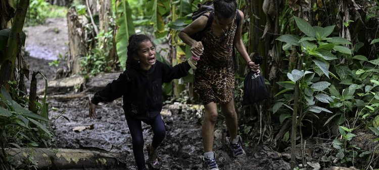 Una niña migrante venezolana es ayudada por su madre cuando llegan a la aldea de Canaán Membrillo, el primer control fronterizo de la provincia de Darién en Panamá.