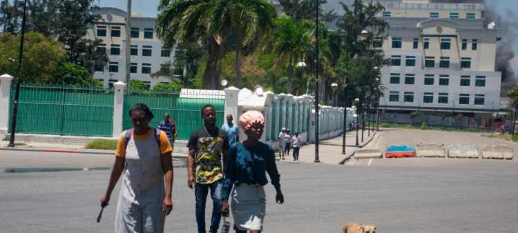 Mientras sale humo del edificio del Ministerio de Finanzas, personas abandona la zona tras oír disparos de bandas armadas cerca del Palacio Nacional en Puerto Príncipe, Haití, el 2 de abril de 2024