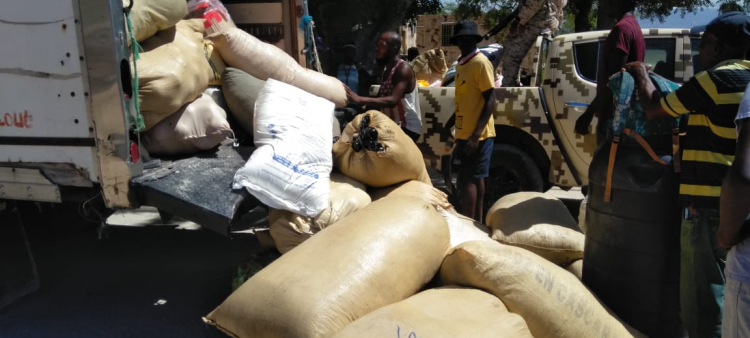 Autoridades desmontan sacos de ropas usadas de un camión en el que también llevaban sacos de arroz que fueron retenidos para que no pasaran hacia Haití.