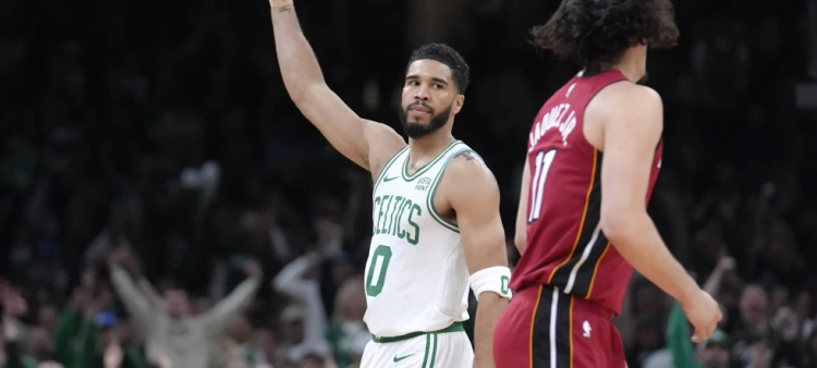 El alero de los Celtics de Boston Jayson Tatum (0) celebra frente al armador mexicano del Heat de Miami Jaime Jaquez Jr. (11), durante la primera mitad del Juego 1 de la serie de primera ronda de postemporada de la NBA.