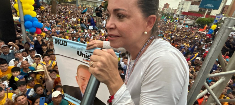 La líder opositora María Corina Machado sostiene una pancarta del candidato presidencial Edmundo González mientras habla a sus seguidores durante un mitin en Maracaibo, Venezuela