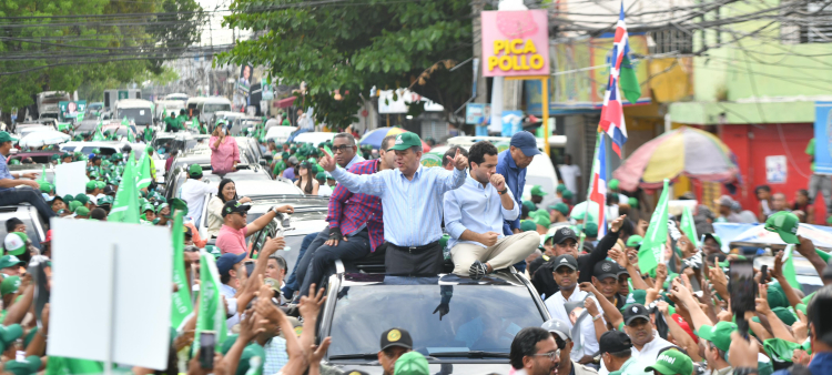 Leonel Fernández y su hijo, Omar, durante la marcha caravana ayer, seguidos por multitudes en las circunscripciones 1 y 3 del Distrito Nacional.