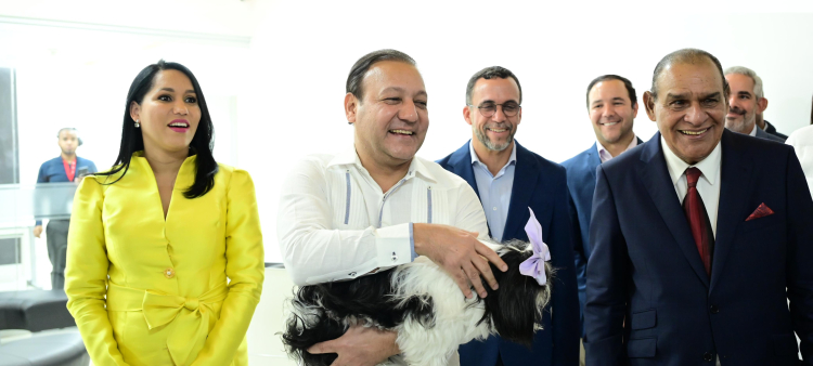 Abel Martínez sostiene a su mascota durante su visita a la redacción central de Listín Diario. A su izquierda la presidenta de la FEDDA, y a su derecha el director del diario, Miguel Franjul.