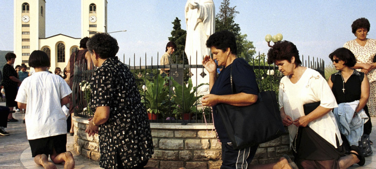 Fieles de la iglesia católica bosnia rezan durante la fiesta de la Asunción en Medjugorje, a unos 120 kilómetros al sur de la capital de Bosnia, Sarajevo, el 15 de agosto de 2000.