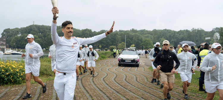 Juan Arturo Herrera Ramírez, saluda durante su recorrido de la llama olímpica. Fue el último de los cinco que llevaron la flama durante un kilómetro.