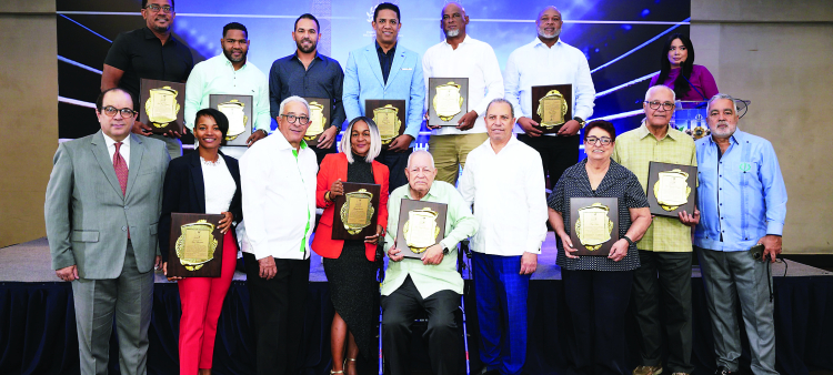 Franklin de la Mota, Dionisio Guzmán y Garibaldi Bautista encabezan la entrega de placa a los deportistas que serán exaltados el domingo. Detrás, desde la izquierda, Joel Ramírez, Félix Díaz, Víctor Estrella, Octavio Dotel, Fernando Hernández y Cristian Cruz. Abajo y en el mismo orden, De la Mota, Ana Villanueva, Guzmán, Wendy Santana, Luis Ángel Montalvo, Bautista, Mayo Sibilia, José Armando Castillo y Pedro Gómez.