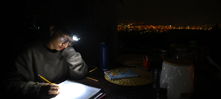 Una estudiante usa un faro para hacer su tarea durante un apagón en Quito, Ecuador, el 13 de noviembre de 2024.