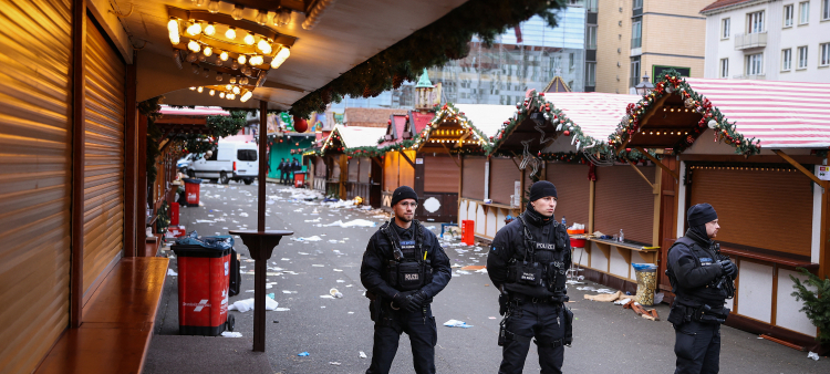 Se ven escombros y puestos cerrados mientras agentes de policía se encuentran en el lugar de un ataque con un coche en un mercado navideño en Magdeburgo, este de Alemania, el 21 de diciembre de 2024, que provocó varias muertes y decenas de heridos.