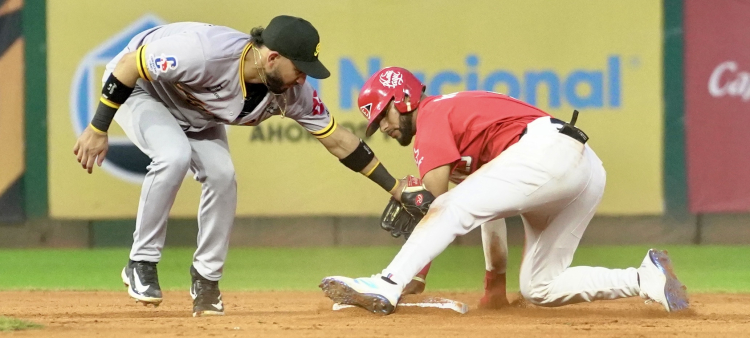 José Caballero trata de poner out a Jean segura, quien se embasó con un doblete para el Escogido