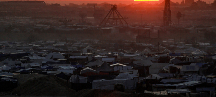 El sol se pone detrás de las tiendas de campaña que albergan a los palestinos desplazados por el conflicto en el complejo de la ciudad residencial de Hamad en el norte de Khan Yunis, en el sur de la Franja de Gaza, el 22 de diciembre de 2024, en medio de la guerra en curso en el territorio palestino entre Israel y Hamás.