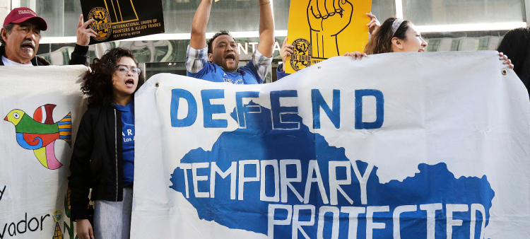 Simpatizantes de los inmigrantes que cuentan con estatus de protección temporal en EE.UU. sostienen letroros, antes de demandar a Donald Trump.