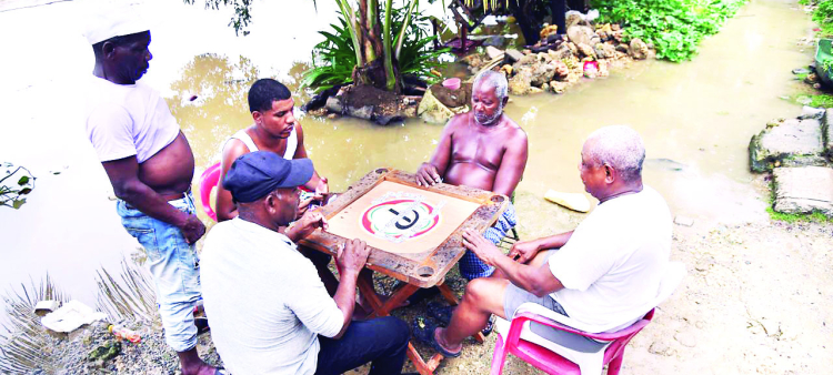 En el sector El Túnel de Capotillo sus habitantes encuentran peculiares formas de pasar el tiempo, jugando dominó en el cauce del río Isabela.