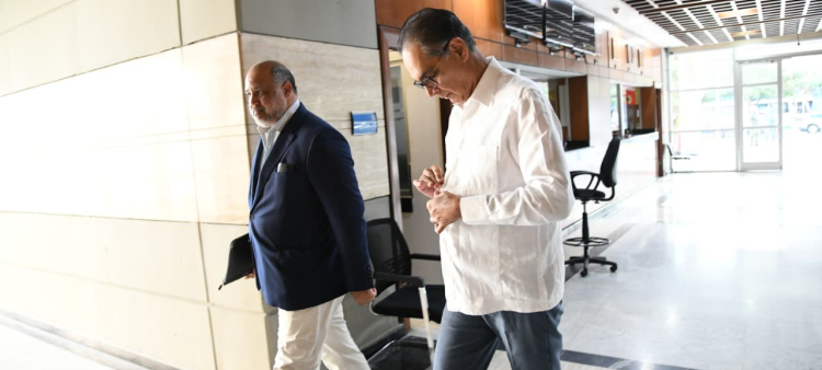 Momento en que el exdirector de Senasa, doctor Santiago Hazim, llegaba junto a su abogado, Miguel Valerio, a la Procuraduría General de la República para ser interrogado.