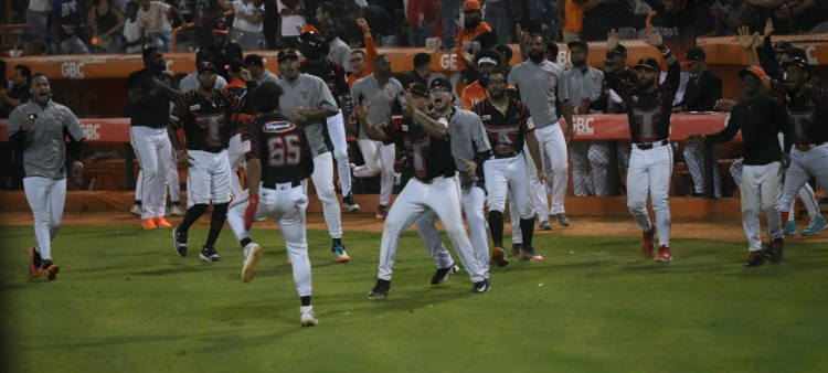 Jugadores y otros miembros del staff de los Toros se lanzan al terreno cuando Bryan de la Cruz anotó forzado la carrera del triunfo.