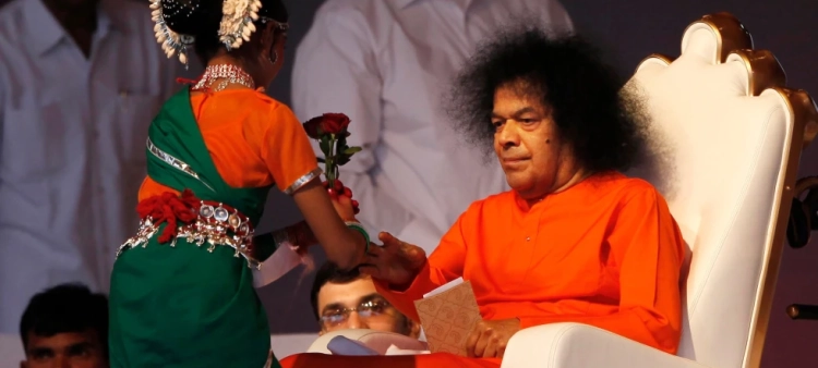 El líder espiritual indio Sathya Sai Baba recibe una flor de una niña en una ceremonia en Nueva Delhi, India, el 10 de abril del 2010.