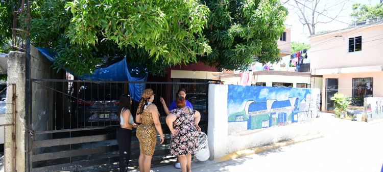 Vecinas se asoman a la casa de mujer ultimada a tiros por su pareja en el sector Barrio Nuevo, en el kilómetro 13 de la carretera Sánchez, Santo Domingo Oeste.