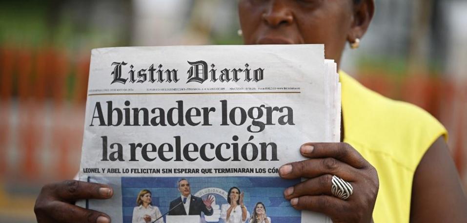 Una mujer vende periódicos nacionales en la calle un día después de las elecciones presidenciales en Santo Domingo el 20 de mayo de 2024.
