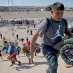 Migrantes buscan cruzar muro de la frontera a la fuerza