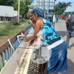 Haitianos se lavan las manos antes de entrar al mercado de Dajabón para evitar el cólera