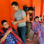Venezolanos varados en la frontera de México subsisten como barberos