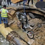 Un hombre cae junto a motocicleta en un hoyo tras intentar cruzar por una calle inundada