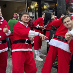 Miles de personas llegan a Nueva York para el recorrido anual por bares con temática de Papá Noel