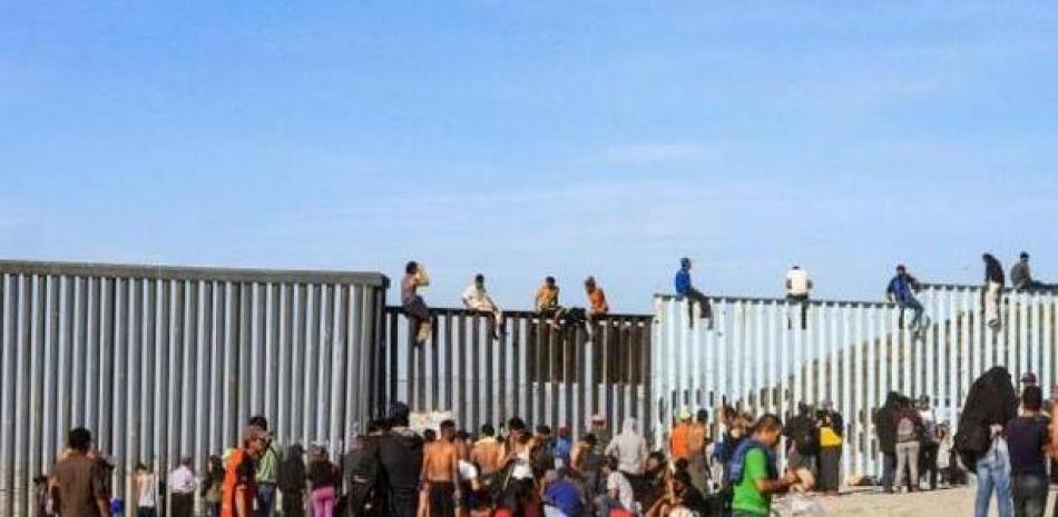Migrantes intentan cruzar el muro fronterizo que divide Estados Unidos de México. Archivo /LD.
