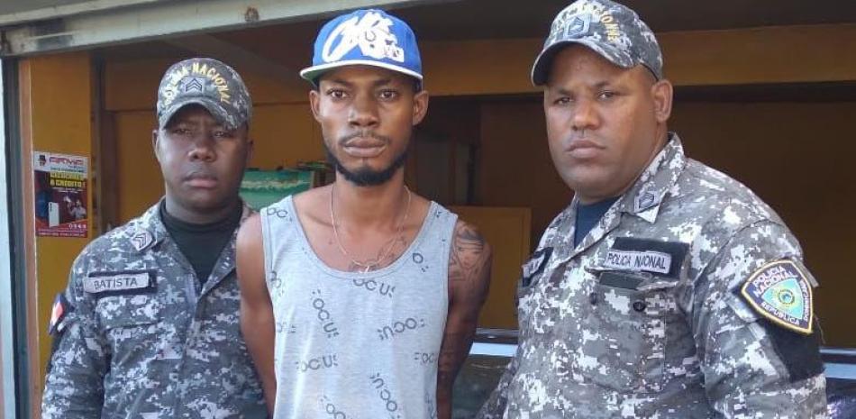 Agentes posan junto al presunto miembro de la peligrosa banda haitiana Yeye
