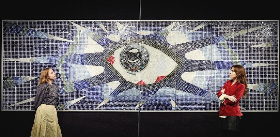 Empleados de la casa de subastas junto a "The Psychedelic Eye", un mosaico encargado por John Lennon para la piscina de su casa de Kenwood en 1965