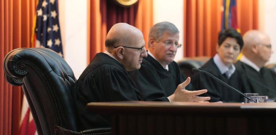 El magistrado de la Corte Suprema de Colorado Carlos Samour Jr. (izquierda) hace una pregunta durante los alegatos orales previo a un juicio, el miércoles 6 de diciembre de 2023, en Denver