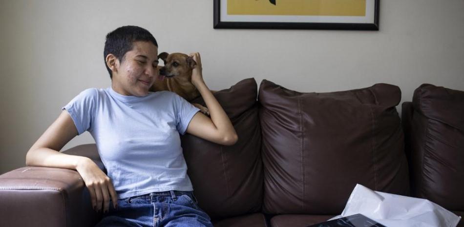 Jaimar Tuarez, de 22 años, estudiante de psicología de la Universidad Central de Venezuela y enferma de esclerosis múltiple, acaricia a su perro en su casa de Charallave, estado de Miranda, Venezuela
