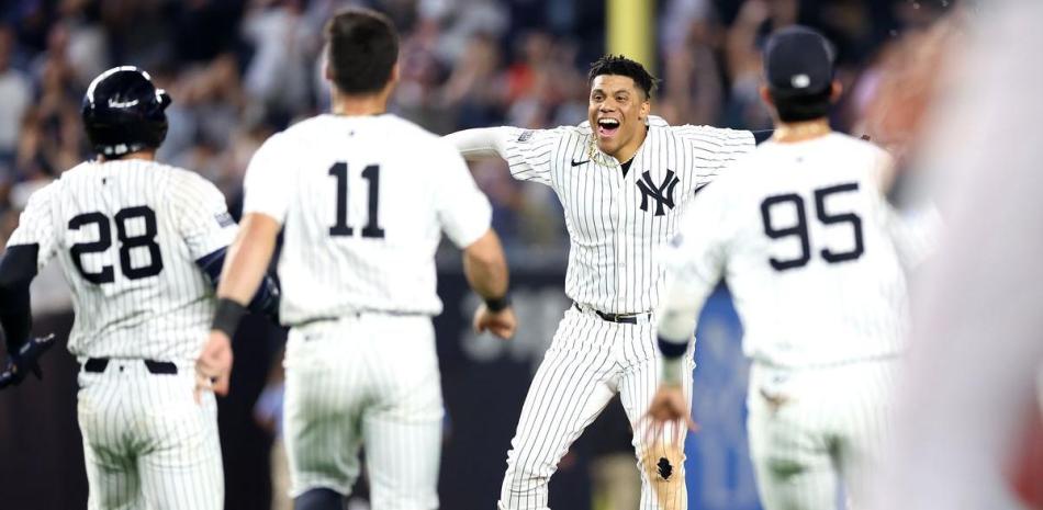 Juan Soto festeja con algunos compañeros luego de disparar un sencillo que le otorgó la victoria a los Yankees.