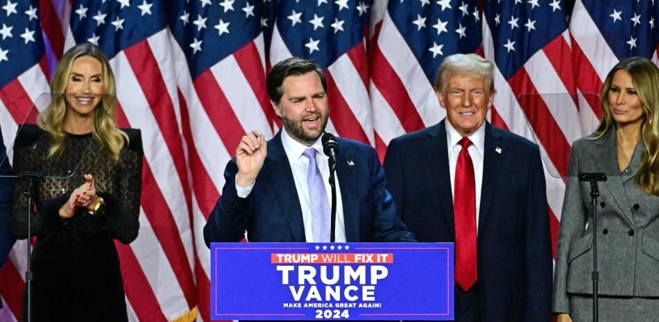US Senator from Ohio and Republican vice presidential candidate J.D. Vance (C) speaks alongside former US President and Republican presidential candidate Donald Trump during an election night event at the West Palm Beach Convention Center in West Palm Beach, Florida, on November 6, 2024. - Republican former president Donald Trump closed in on a new term in the White House early November 6, 2024, just needing a handful of electoral votes to defeat Democratic Vice President Kamala Harris. (Photo by Jim WATSON / AFP)