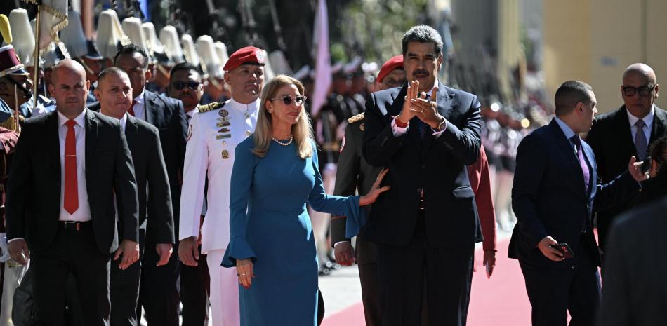 El presidente de Venezuela, Nicolás Maduro (centro), y la primera dama, Cilia Flores, caminan a su llegada al Capitolio para la investidura presidencial, en Caracas, el 10 de enero de 2025.